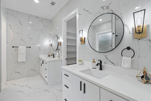 bathroom with stone wall, a sink, and visible vents