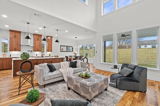 living room featuring recessed lighting, plenty of natural light, visible vents, and light wood-style floors