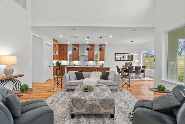 living room featuring light wood-style flooring, visible vents, baseboards, and recessed lighting