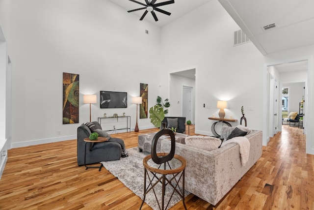 living area featuring light wood-style floors, baseboards, and visible vents