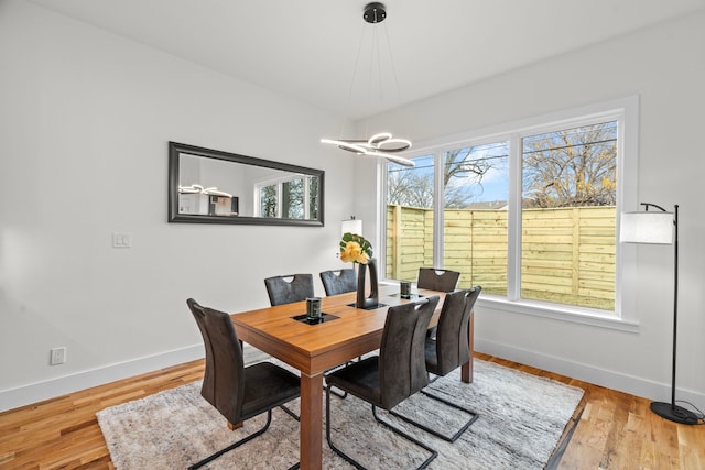 dining area with a chandelier, baseboards, and wood finished floors