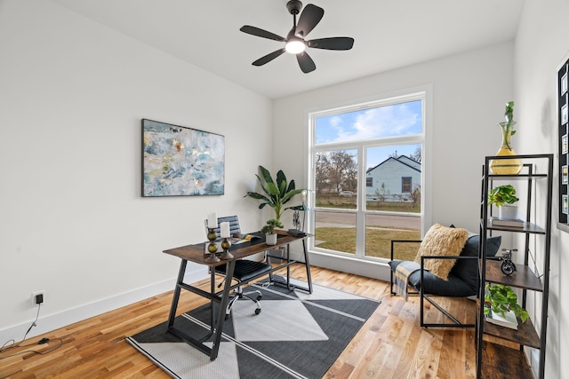 office with light wood-style floors, baseboards, and a ceiling fan