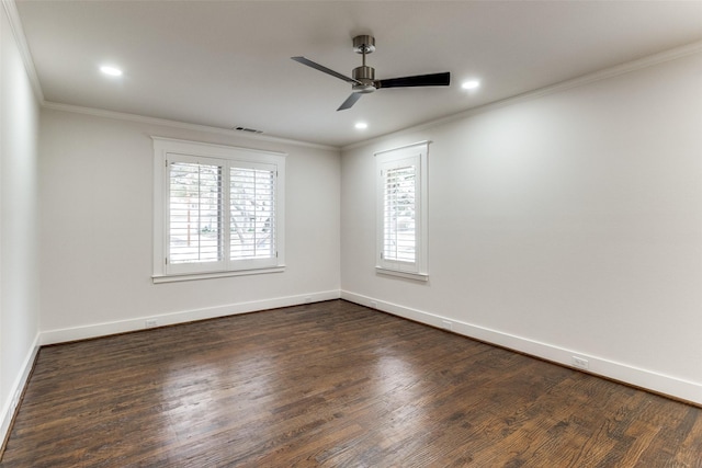 spare room featuring dark wood finished floors, visible vents, crown molding, and baseboards