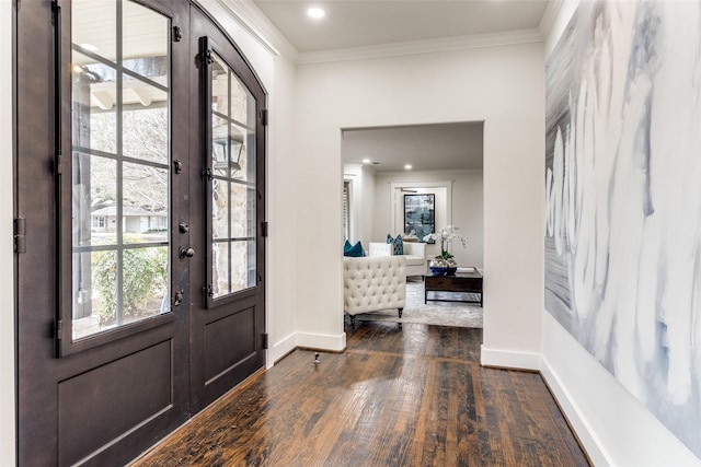 foyer featuring ornamental molding, dark wood-style flooring, and baseboards