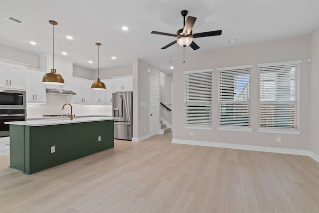 kitchen featuring under cabinet range hood, visible vents, stainless steel appliances, and a sink