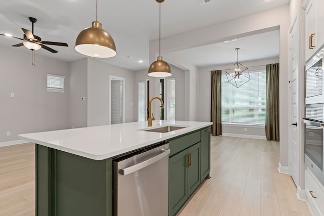 kitchen with light countertops, appliances with stainless steel finishes, a sink, and green cabinetry