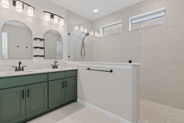 full bathroom featuring marble finish floor, double vanity, walk in shower, and a sink