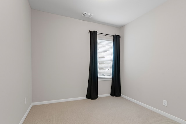 empty room with light carpet, visible vents, and baseboards