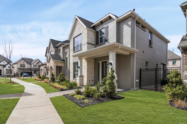 view of side of property with brick siding, a lawn, fence, a residential view, and stone siding