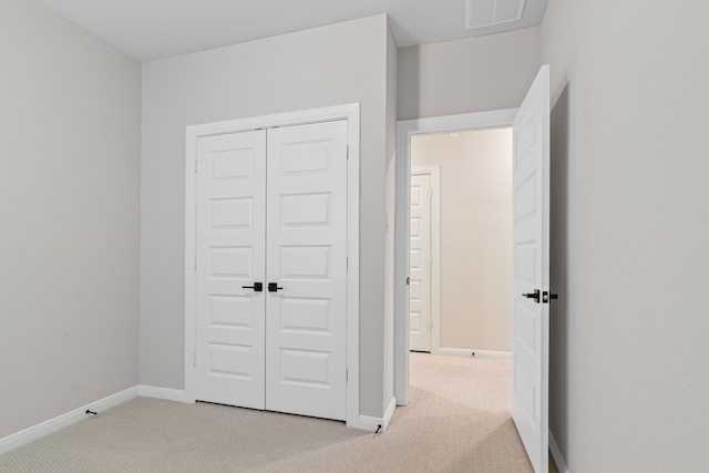 unfurnished bedroom featuring a closet, visible vents, baseboards, and carpet flooring