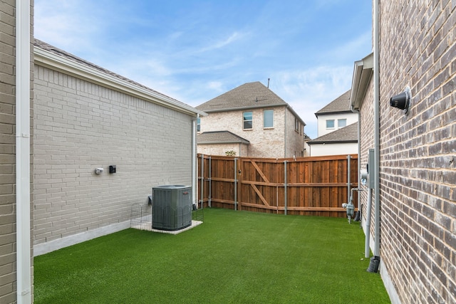 view of yard with central AC unit and fence