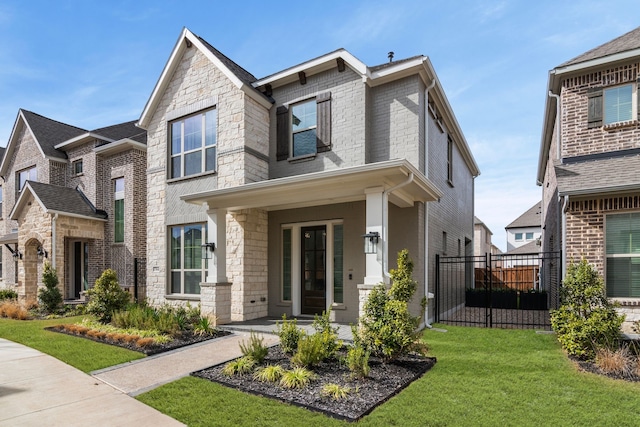 view of front of home with a front lawn, fence, and brick siding