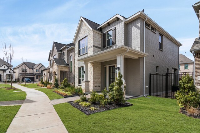 view of front of house with stone siding, brick siding, fence, and a front lawn