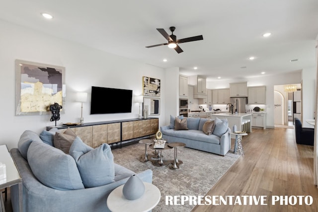 living room with a ceiling fan, recessed lighting, and light wood finished floors