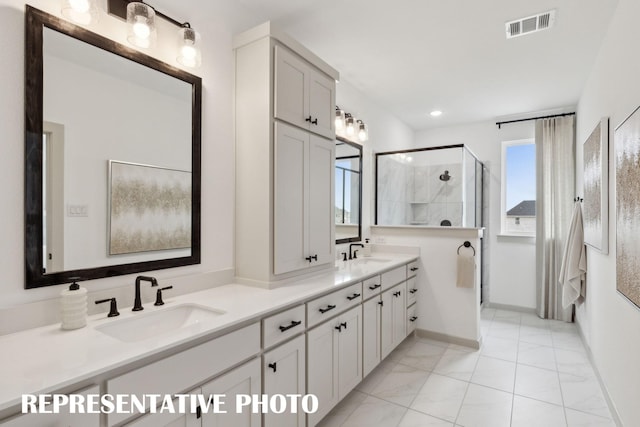 bathroom featuring marble finish floor, a shower stall, visible vents, and a sink