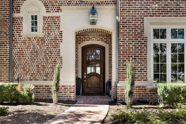 property entrance featuring brick siding