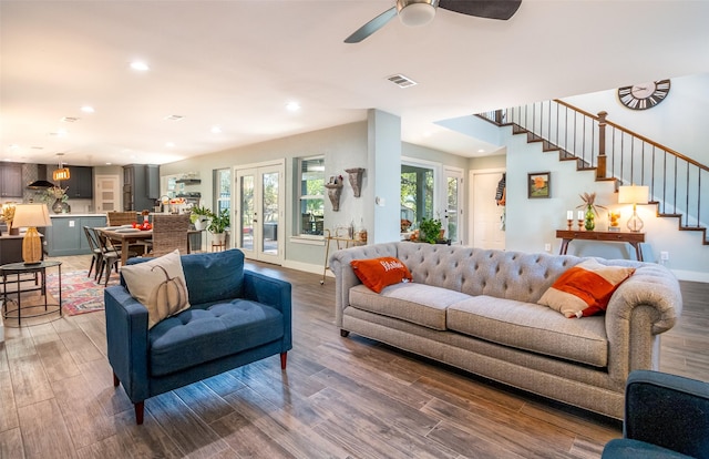 living area with recessed lighting, visible vents, stairway, wood finished floors, and baseboards