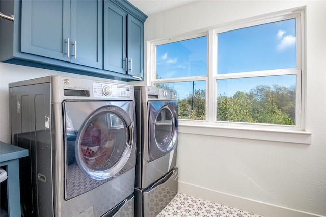 washroom with light floors, independent washer and dryer, cabinet space, and baseboards