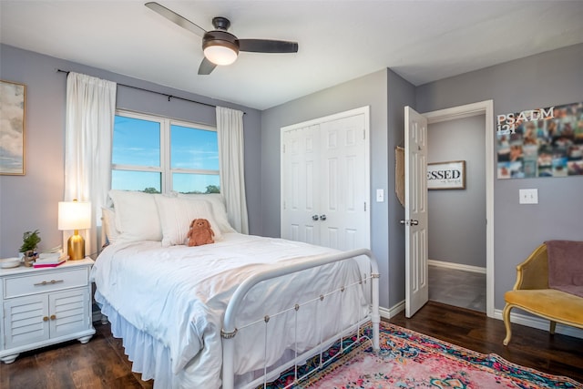 bedroom with ceiling fan, dark wood-type flooring, a closet, and baseboards