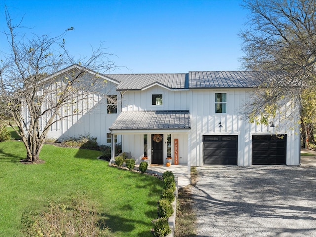 modern farmhouse style home featuring board and batten siding, a front yard, metal roof, a garage, and driveway