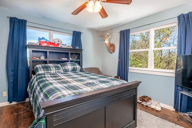 bedroom featuring ceiling fan, wood finished floors, and baseboards