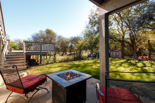 view of patio / terrace featuring an outdoor fire pit, a fenced backyard, stairs, a storage unit, and an outdoor structure