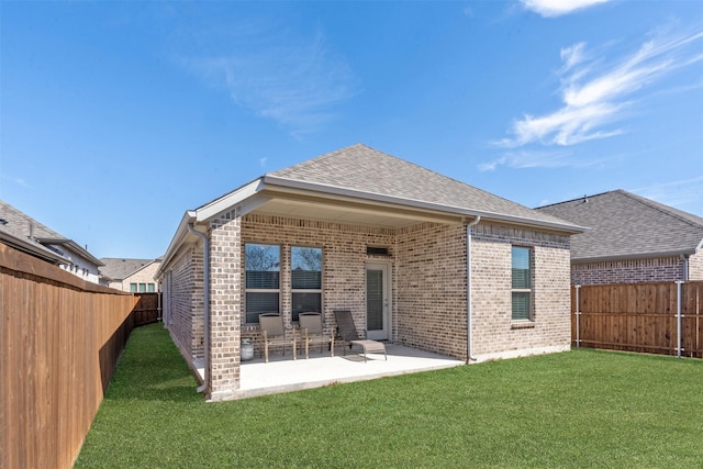 back of property featuring a patio area, brick siding, a yard, and a fenced backyard