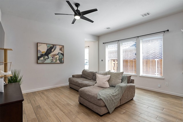 living area featuring light wood-style floors, visible vents, and baseboards