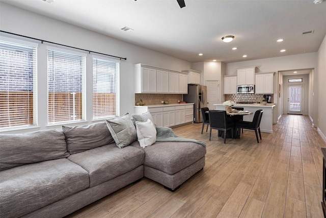 living room featuring recessed lighting, visible vents, ceiling fan, and light wood finished floors