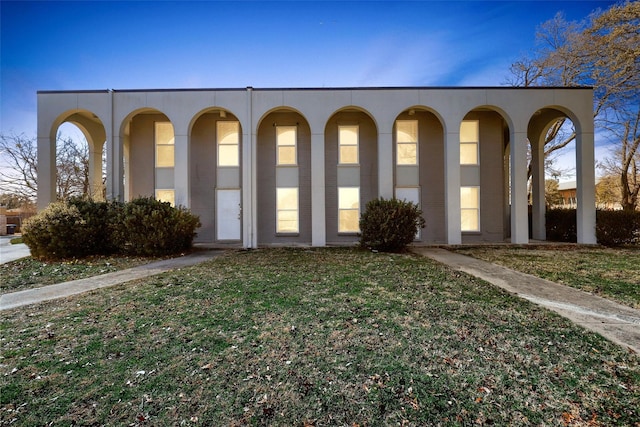 view of front facade featuring a front yard and stucco siding