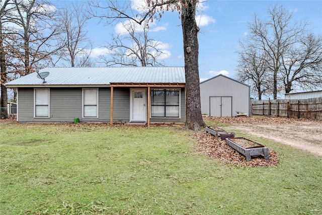 rear view of house with a yard, metal roof, fence, and a pole building