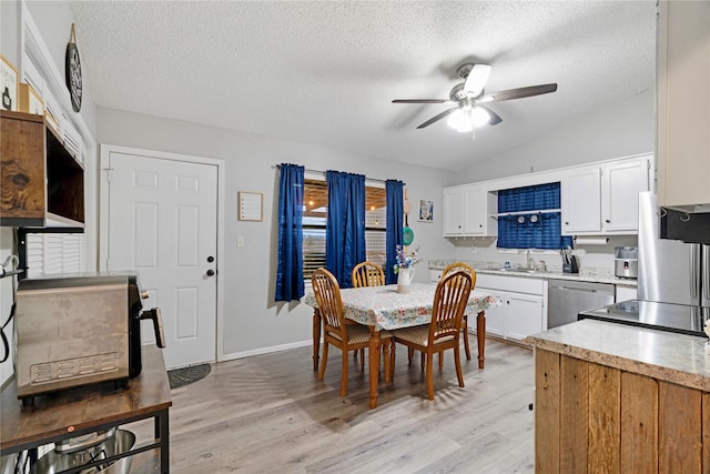 dining area with vaulted ceiling, ceiling fan, a textured ceiling, and light wood-style floors