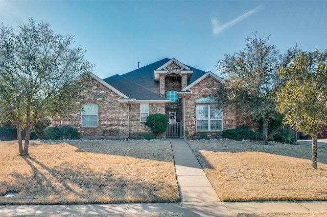 view of front facade featuring brick siding and a front yard