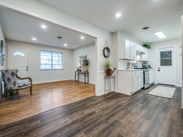 kitchen featuring visible vents, under cabinet range hood, light countertops, stainless steel range oven, and white cabinetry