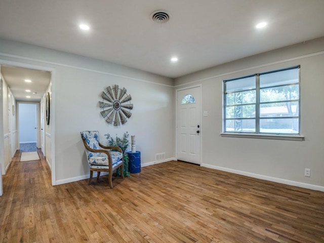 foyer with recessed lighting, wood finished floors, visible vents, and baseboards