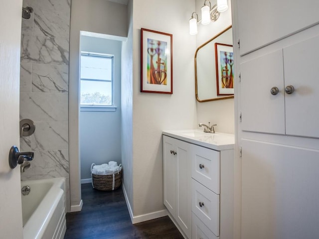 bathroom featuring washtub / shower combination, baseboards, wood finished floors, and vanity