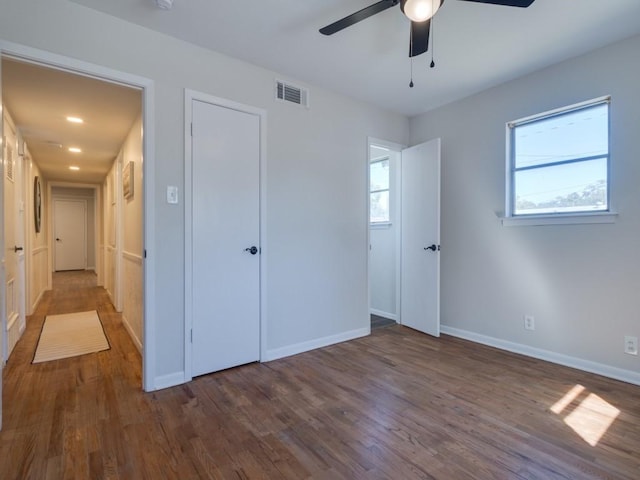 unfurnished bedroom with wood finished floors, visible vents, and multiple windows