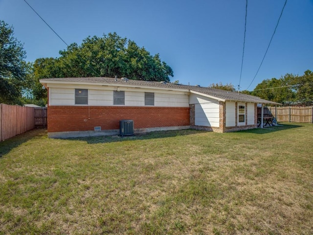 view of property exterior with a yard, a fenced backyard, brick siding, and central AC