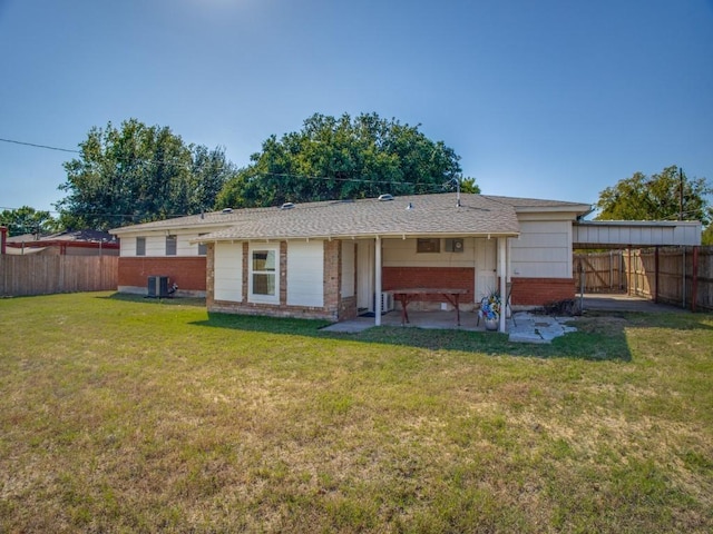 rear view of property featuring a yard, a fenced backyard, cooling unit, and brick siding