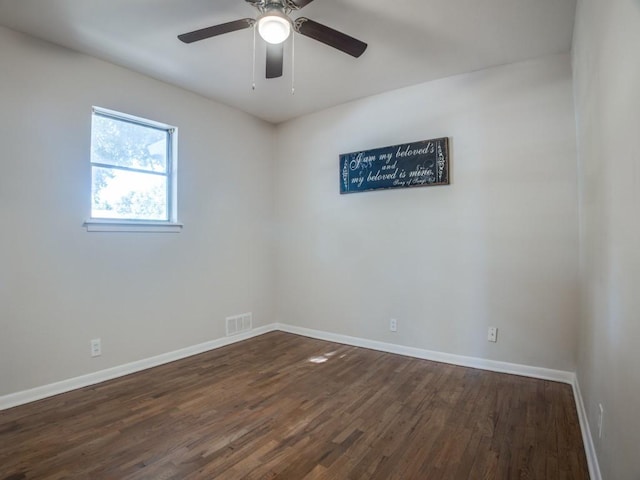 spare room with ceiling fan, dark wood finished floors, visible vents, and baseboards