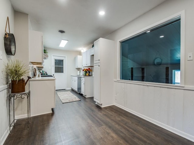 kitchen with dark wood-type flooring, visible vents, white cabinetry, light countertops, and stainless steel dishwasher