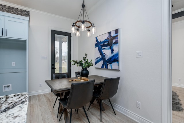 dining space with a notable chandelier, crown molding, light wood-style flooring, and baseboards