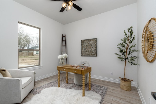 office space featuring light wood-style floors, ceiling fan, and baseboards