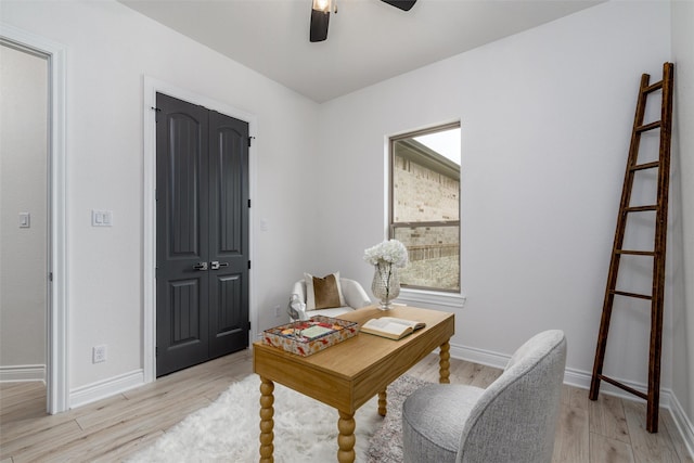 office space with light wood-style floors, ceiling fan, and baseboards