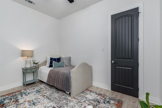 bedroom featuring a ceiling fan, baseboards, visible vents, and light wood finished floors