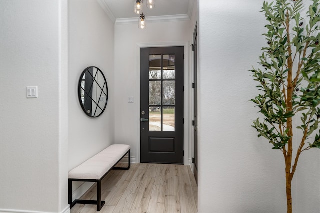 foyer featuring baseboards, crown molding, and light wood finished floors