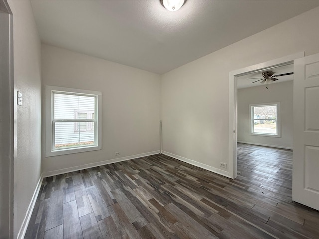 spare room featuring dark wood-style flooring and baseboards