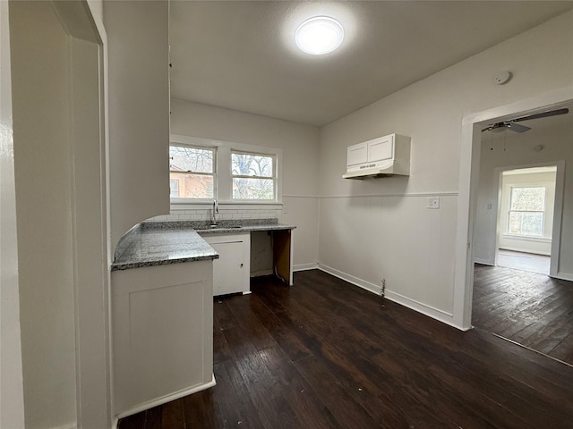 kitchen featuring baseboards, a ceiling fan, dark wood-type flooring, white cabinetry, and a sink