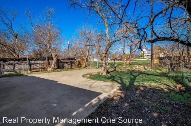 view of yard with driveway, fence, and a patio