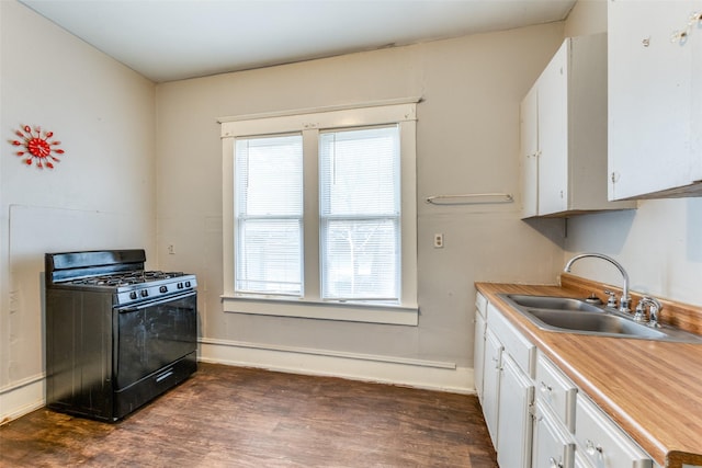 kitchen with a sink, black gas stove, baseboards, white cabinetry, and dark wood-style floors